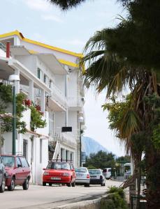 uma rua com carros estacionados em frente a um edifício em Apartments with a parking space Drvenik Gornja vala, Makarska - 4890 em Drvenik