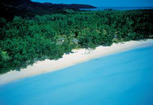 een luchtzicht op een strand met bomen en water bij Hotel Cote d'or Lodge in Baie Sainte Anne
