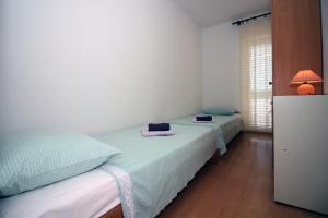 a bedroom with two beds and a lamp in it at Apartments by the sea Tisno, Murter - 5136 in Tisno