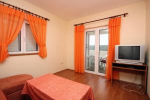 a living room with a tv and a window at Apartments with a parking space Kampor, Rab - 5018 in Rab