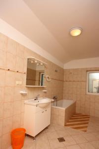 a bathroom with a sink and a bath tub at Apartments with a parking space Kampor, Rab - 5018 in Rab