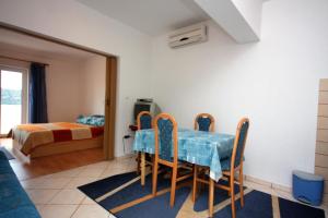 a dining room with a table and chairs and a bed at Apartments with a parking space Kampor, Rab - 5018 in Rab