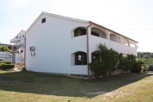 a white building with windows on the side of it at Apartments for families with children Lopar, Rab - 5024 in Lopar