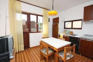 a kitchen with a table and two chairs and a television at Apartments by the sea Maslinica, Solta - 5188 in Maslinica