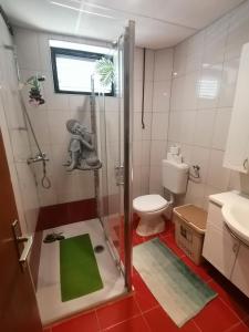 uma casa de banho com um chuveiro e um WC. em Apartments for families with children Lopar, Rab - 5024 em Lopar