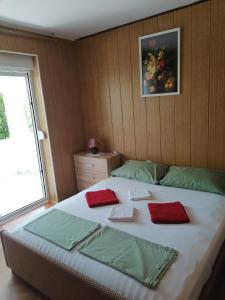 um quarto com uma cama grande com almofadas vermelhas em Apartments for families with children Lopar, Rab - 5024 em Lopar
