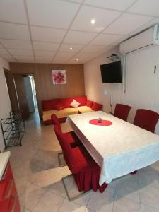 um quarto com uma mesa e cadeiras vermelhas e uma cama em Apartments for families with children Lopar, Rab - 5024 em Lopar