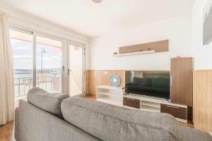 a living room with two couches and a flat screen tv at Primera línea con preciosas vistas al mar in Melenara