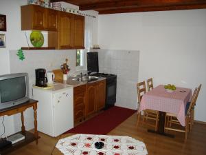 a kitchen with a sink and a table and a tv at Apartments with a parking space Kampor, Rab - 5014 in Kampor