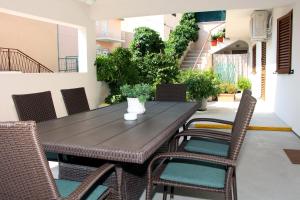 een houten tafel en stoelen op een patio bij Apartments and rooms by the sea Tisno, Murter - 5106 in Tisno