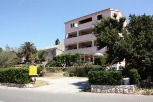 a building on the side of a road at Apartments and rooms with parking space Barbat, Rab - 5070 in Rab