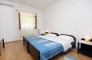 a bedroom with a large bed and a window at Apartments and rooms by the sea Cove Saplunara, Mljet - 4907 in Saplunara