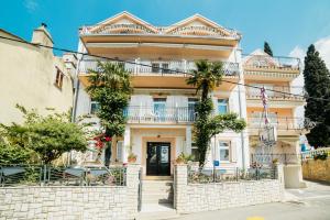 Cette grande maison blanche dispose d'un balcon. dans l'établissement Apartments by the sea Selce, Crikvenica - 5206, à Selce