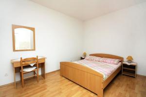 1 dormitorio con cama, escritorio y espejo en Apartments by the sea Cove Saplunara, Mljet - 4896, en Maranovići