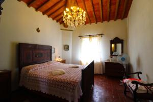 a bedroom with a large bed and a chandelier at Villa Cecilia in Castiglion Fiorentino