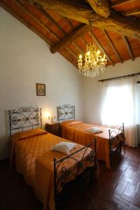 カスティリオーン・フィオレンティーノにあるVilla Ceciliaのベッドルーム1室(ベッド2台、シャンデリア付)