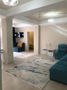 ein Wohnzimmer mit einem blauen Sofa und einem Teppich in der Unterkunft Квартира на первой береговой линии in Bosteri
