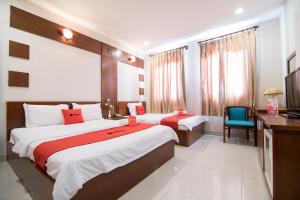 Cette chambre comprend deux lits et un bureau. dans l'établissement Phuong Thuy Hotel Thu Duc near QL13, à Hô-Chi-Minh-Ville