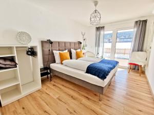 a bedroom with a bed with orange and blue pillows at Haus Waltl in Sankt Johann in Tirol