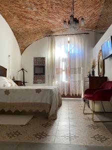 ein Schlafzimmer mit einem Bett und einem großen Fenster in der Unterkunft Dimora Ferraris in Càbras
