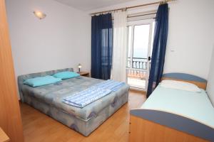 a bedroom with two beds and a large window at Apartments with a parking space Zivogosce - Porat, Makarska - 6700 in Igrane
