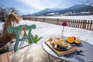 een dienblad met eten op een tafel in de sneeuw bij Haus Waltl in Sankt Johann in Tirol