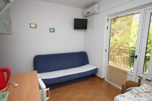 a room with a blue couch and a window at Apartments with a parking space Zivogosce - Porat, Makarska - 6700 in Igrane