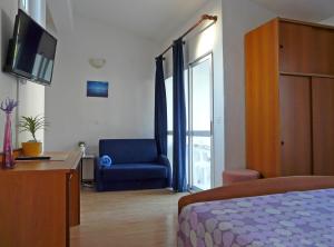 ein Schlafzimmer mit einem Bett, einem Stuhl und einem Schreibtisch in der Unterkunft Apartments by the sea Drvenik Donja vala, Makarska - 6756 in Drvenik