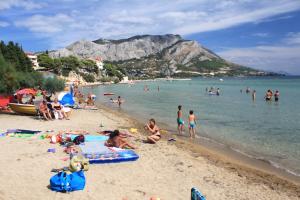 a group of people on a beach in the water at Apartments with a parking space Duce, Omis - 9437 in Dugi Rat