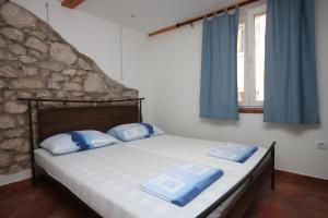 a bedroom with a bed with blue and white pillows at Apartments by the sea Gradac, Makarska - 6661 in Gradac