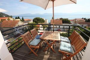 a table and chairs on a balcony with an umbrella at Apartments by the sea Gradac, Makarska - 6661 in Gradac