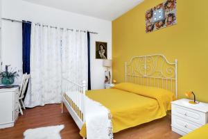 1 dormitorio con cama y pared amarilla en Apartments with a parking space Makarska - 6909 en Makarska