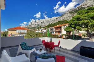 a balcony with a table and chairs and a mountain at Apartments with a parking space Makarska - 6909 in Makarska