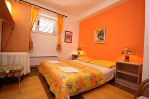 - une chambre avec des murs orange, un lit et une fenêtre dans l'établissement Apartments with a parking space Makarska - 6636, à Makarska
