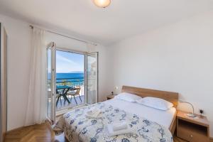 um quarto com uma cama e vista para o oceano em Apartments by the sea Podgora, Makarska - 6789 em Podgora