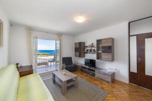 uma sala de estar com um sofá, uma mesa e uma janela em Apartments by the sea Podgora, Makarska - 6789 em Podgora