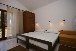 a bedroom with a bed and a chair and a window at Apartments by the sea Zaostrog, Makarska - 6799 in Podaca