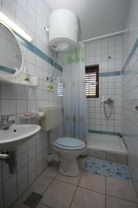 a bathroom with a toilet and a sink and a tub at Apartments by the sea Zaostrog, Makarska - 6799 in Podaca