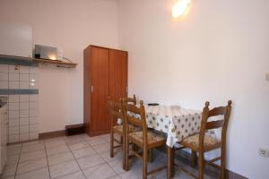 a kitchen with a table and chairs in a room at Apartments by the sea Zaostrog, Makarska - 6799 in Podaca +25 photos