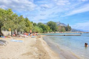 a group of people on a beach in the water at Apartments by the sea Duce, Omis - 5987 in Duće