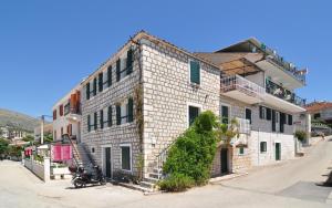 a white brick building with a staircase on the side of it at Apartments by the sea Seget Vranjica, Trogir - 6597 in Seget Vranjica