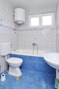 a bathroom with a toilet and a tub and a sink at Apartments by the sea Seget Vranjica, Trogir - 6597 in Seget Vranjica