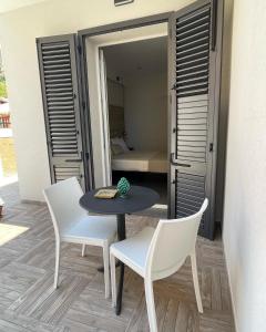 a table and chairs on a patio with a bedroom at Oneira Rooms in Agrigento