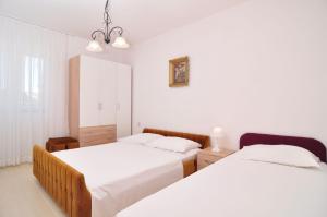 two beds in a room with white walls at Apartments by the sea Seget Vranjica, Trogir - 6597 in Seget Vranjica