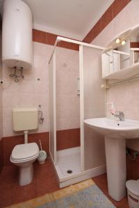 łazienka z prysznicem, toaletą i umywalką w obiekcie Apartments by the sea Povljana, Pag - 6502 w mieście Povljana