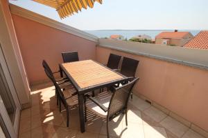 a table and chairs on a balcony with a view at Apartments by the sea Mandre, Pag - 6507 in Kolan