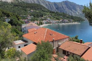 a group of buildings with orange roofs next to a lake at Apartments by the sea Podgora, Makarska - 6764 in Podgora