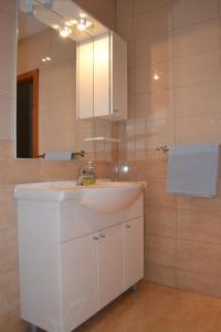 a bathroom with a white sink and a mirror at Apartments with a parking space Makarska - 6792 in Makarska