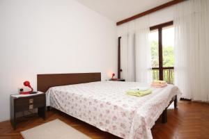 a bedroom with a bed and a window at Apartments by the sea Starigrad, Paklenica - 6626 in Starigrad