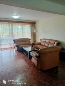 a living room with two leather couches and a table at China Garden in Nairobi